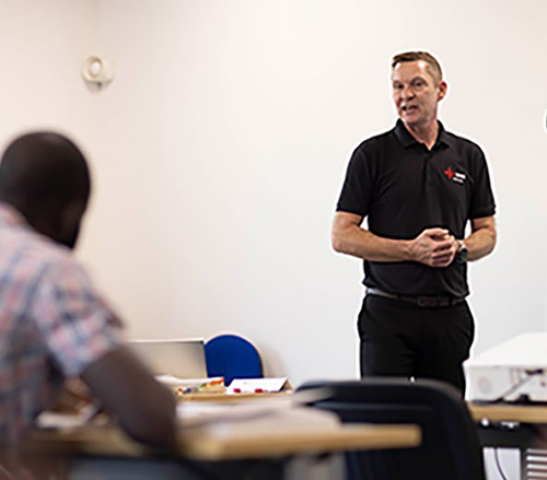 An NICEIC tutor giving a presentation in a classroom setting