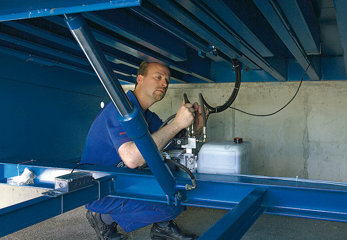 A FBS Hörmann worker repairing some hydraulic machinery