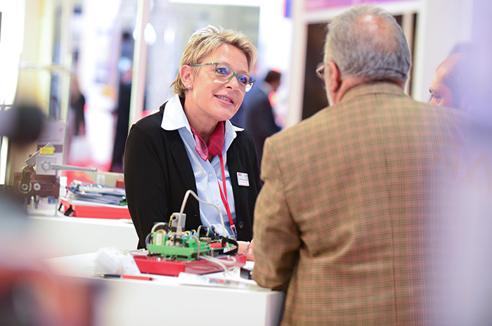 A LIFTEX' exhibitor speaking to an attendee at her stand
