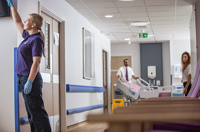 Mitie worker cleaning in a hospital corridor
