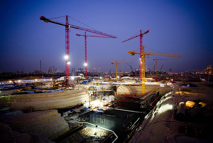 Construction site with cranes viewed at night