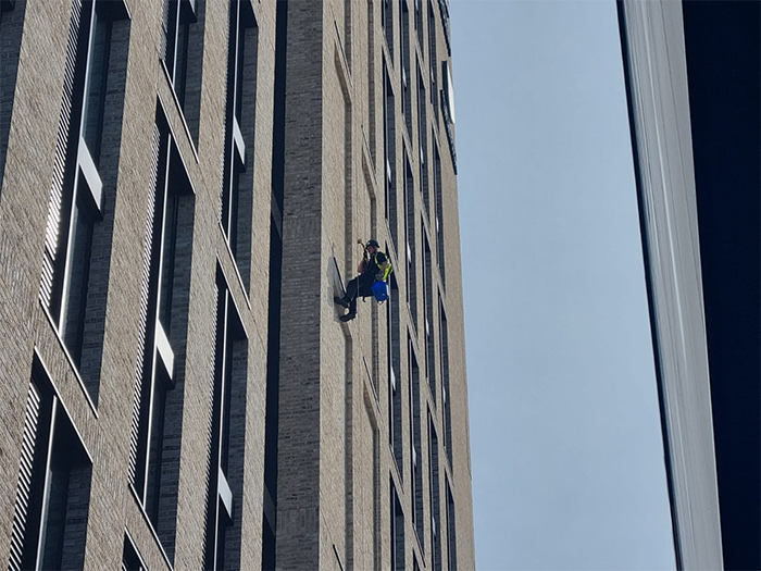 A PTSG technician abseiling down a building at the University of Birmingham