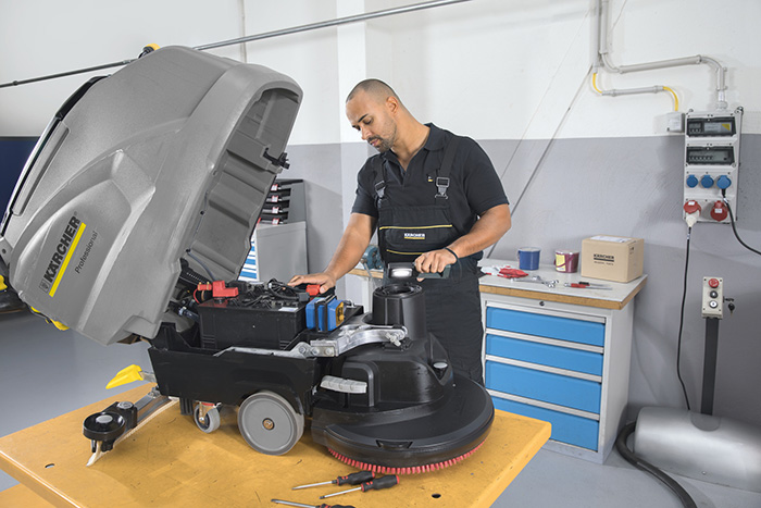 A Kärcher expert disassembling a cleaning machine to inspect and refurbish it