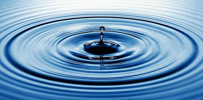 A droplet creating ripples in a pool of water